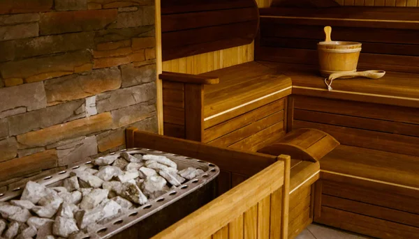 Taş ile dolu bir Isıtma pot ile ahşap bathhouse, yakın. Ahşap sauna iç ekipmanları, kömürleri, kepçe, kova.