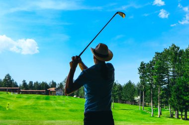 Man silhouette in a cowboy hat playing golf on a green grass court, sunny weather. clipart