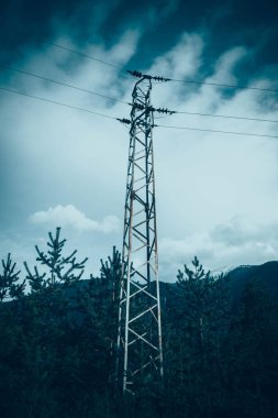 Bulutlu mavi parlak Moody akşam gökyüzü üzerinde teller ile bir yüksek voltaj güçlü elektrik Kulesi tasvir fotoğraf.