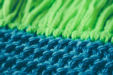 Triko yün Tekstil doku zemin, makro. Mavi ve yeşil renk paleti giysiler, eşarp Püskül.