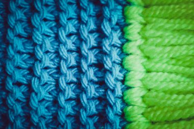 Triko yün Tekstil doku zemin, makro. Mavi ve yeşil renk paleti giysiler, eşarp Püskül.