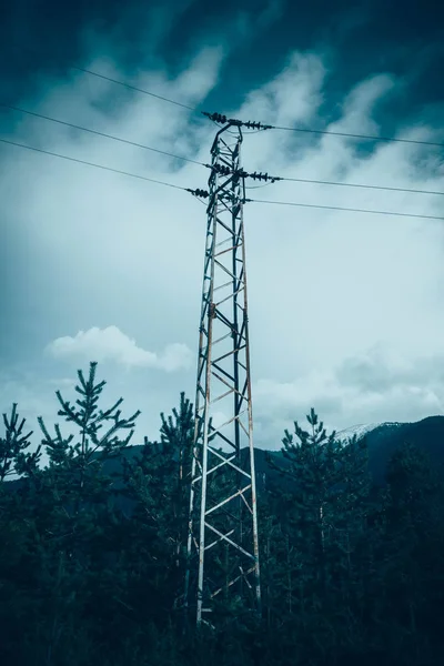 Bulutlu mavi parlak Moody akşam gökyüzü üzerinde teller ile bir yüksek voltaj güçlü elektrik Kulesi tasvir fotoğraf.