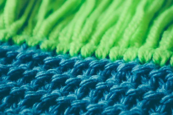 Triko yün Tekstil doku zemin, makro. Mavi ve yeşil renk paleti giysiler, eşarp Püskül.