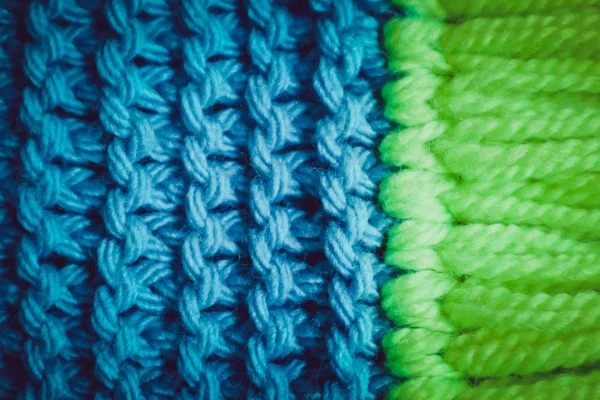 Triko yün Tekstil doku zemin, makro. Mavi ve yeşil renk paleti giysiler, eşarp Püskül.