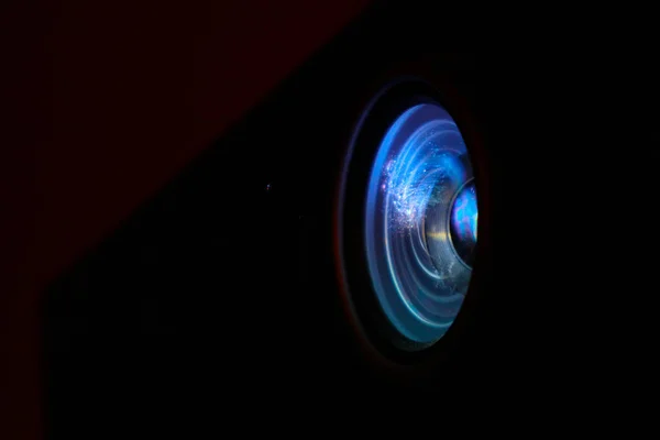 Fotoğraf dijital projektör film tanıtımı gösteriyor. Projektör parlak renkli cam objektif portre, makro görünümü, siyah arka plan.