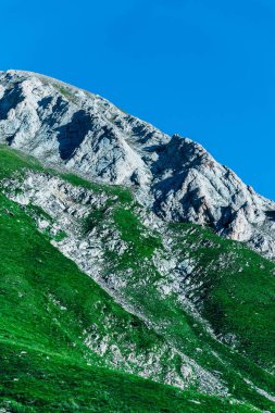 Güzel alp yüksek dağları doruklarına, mavi gökyüzü arka plan, yaz. Şaşırtıcı yeşil alanları ile iz hiking, manzara.
