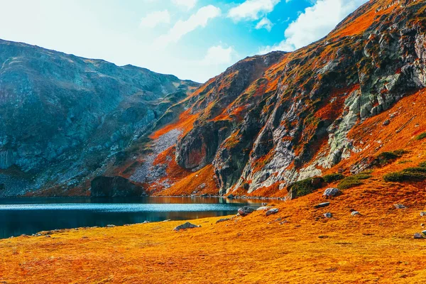 Autumn yellow alpine landscape, clean water in the alpine lake. Rocky mountains, colorful fall season.