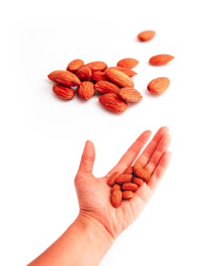 Badem fındık yığını bir elini tut. Beyaz arka plan üzerinde izole bir yığın badem.