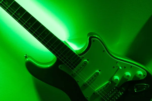 Abstract electro guitar closeup, green background.