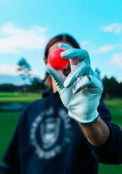 장갑으로 빨간색 골프공를 보여주는 골퍼의 닫습니다 하늘과 배경에서 — 스톡 사진