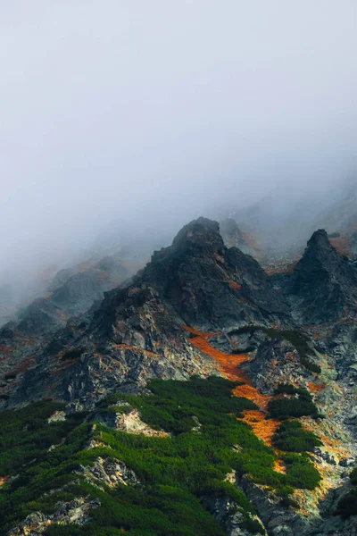 Foggy mountain peak, autumn nature. Clouds in rocky mountains, natural backdrop.