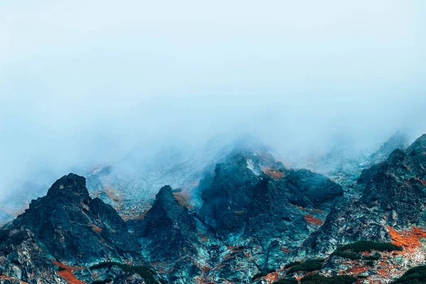 Foggy mountain peak, autumn nature. Clouds in rocky mountains, natural backdrop.