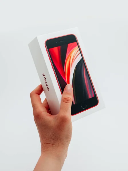フランス 2020年5月1日 白い背景に新しい赤いApple Iphone Se第2世代ボックスを保持する手 ストック画像
