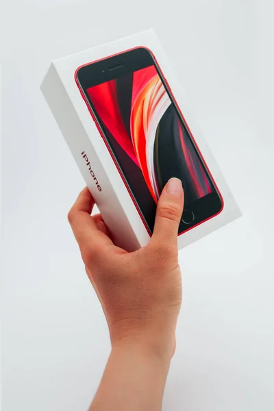 フランス 2020年5月1日 白い背景に新しい赤いApple Iphone Se第2世代ボックスを保持する手 ストックフォト