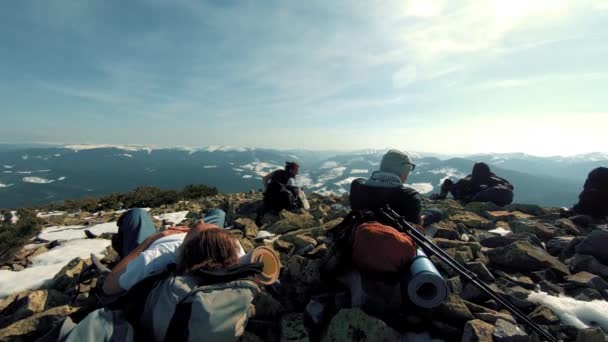 Un gruppo di turisti viaggia tra le montagne innevate — Video Stock