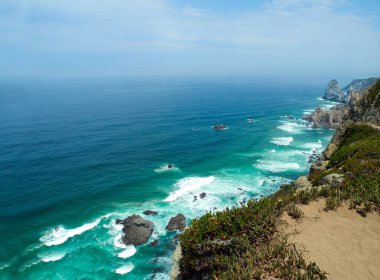 Cabo de Roca (Cape Roca) - Portekiz, Atlantik Okyanusu 'nun panoramik manzarası. Uçurumlar ve turkuaz mavi okyanus suları için güzel bir manzara..                     
