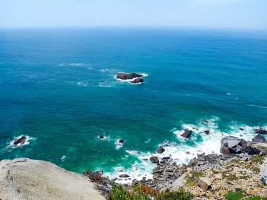 Atlantik Okyanusu ve uçurumlar. Okyanusun parlak turkuaz suları. Güneşli bir yaz günü. Portekiz. 