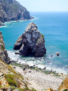 Atlantik Okyanusu ve uçurumlar. Okyanusun parlak turkuaz suları. Güneşli bir yaz günü. Portekiz. 