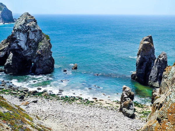 Atlantic ocean and cliffs. Bright turquoise waters of ocean. Sunny summer day. Portugal.