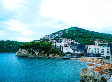 Budva, Karadağ. Adriyatik Denizi 'nin (Akdeniz) ortaçağ duvarları ve turuncu kiremit çatıları ve turkuaz suları. Harika bir manzara.                           