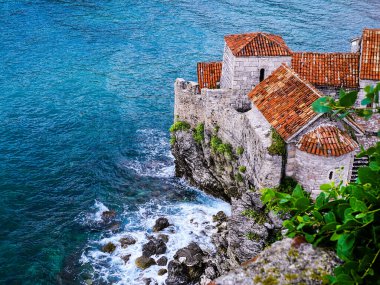 Budva, Karadağ. Adriyatik Denizi 'nin (Akdeniz) ortaçağ duvarları ve turuncu kiremit çatıları ve turkuaz suları. Harika bir manzara.                           