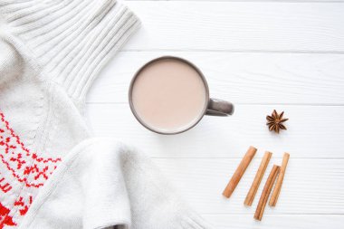 Bir fincan lezzetli kakao ve beyaz ahşap masa zemininde yün kış süveteri.. 
