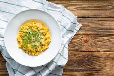 Kırsal ahşap zemin üzerinde risotto (sonbahar), üst görünüm. Parmesanlı ve kremalı balkabağı.. 