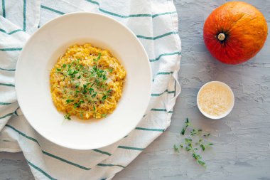 Gri beton arka planda lezzetli balkabaklı risotto. Sonbahar lezzetli yemekler, üst manzara.. 