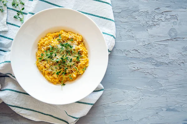 Parmesanlı balkabaklı risotto, gri beton arka plan, metin için yer, kopyalama alanı. Üst görünüm. 