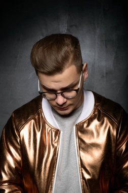 Gri bir arka plan üzerinde modern moda moda giysiler içinde stüdyoda poz genç bir erkek erkek model moda fotoğraf portresi