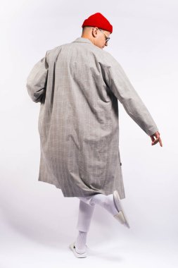 Beyaz ve renkli jel arka plan üzerinde stüdyoda moda modern kentsel görünüm ve duygular poz genç bir erkek model moda fotoğrafı
