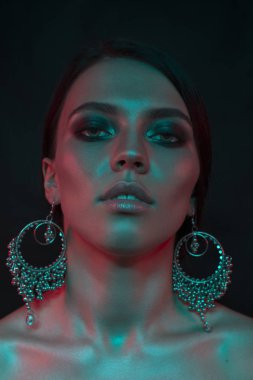 Koyu siyah bir arka plan üzerinde stüdyoda trendy modern jel ışık genç bir güzel çekici kız modeli Moda trendy portre fotoğrafı