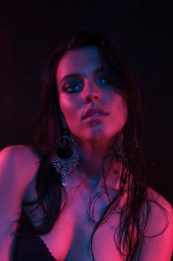 Koyu siyah bir arka plan üzerinde stüdyoda trendy modern jel ışık genç bir güzel çekici kız modeli Moda trendy portre fotoğrafı