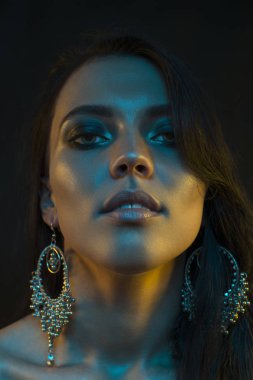 Koyu siyah bir arka plan üzerinde stüdyoda trendy modern jel ışık genç bir güzel çekici kız modeli Moda trendy portre fotoğrafı