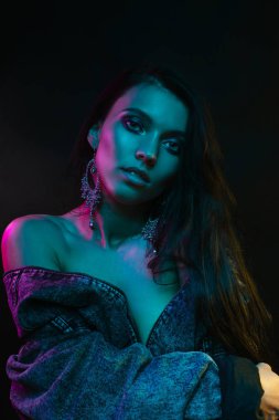 Koyu siyah bir arka plan üzerinde stüdyoda trendy modern jel ışık genç bir güzel çekici kız modeli Moda trendy portre fotoğrafı