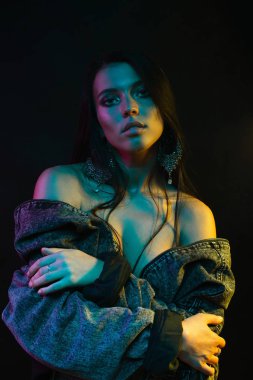 Koyu siyah bir arka plan üzerinde stüdyoda trendy modern jel ışık genç bir güzel çekici kız modeli Moda trendy portre fotoğrafı