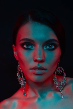 Koyu siyah bir arka plan üzerinde stüdyoda trendy modern jel ışık genç bir güzel çekici kız modeli Moda trendy portre fotoğrafı