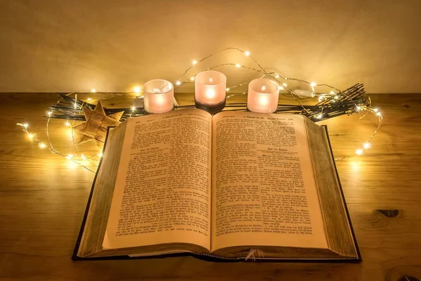 木製の机の上のろうそくで飾られた古いドイツ語聖書 — ストック写真