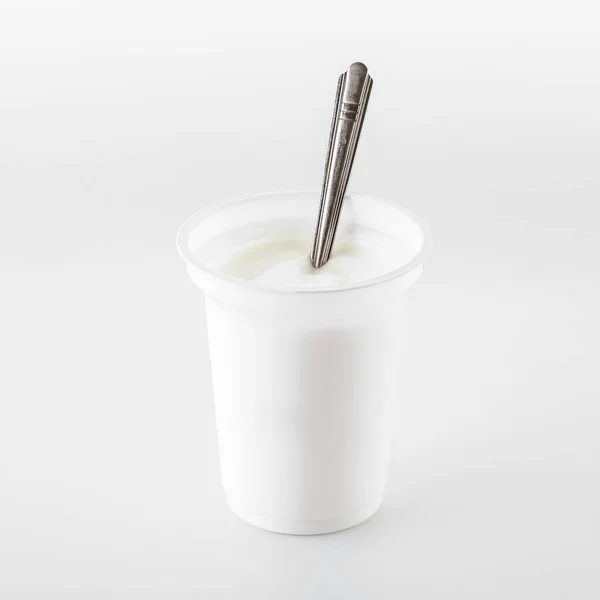 Beyaz arka planda izole edilmiş bir bardak yoğurt. Bir açıdan üstten bak. Tasarım için.