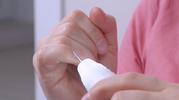 Een mens maakt een manicure op handen thuis met een elektrisch apparaat. — Stockvideo