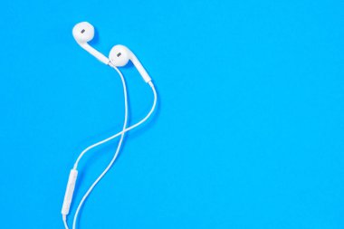 Güvenli telefon kullanımı için mikrofonlu rahat kulaklıklar veya mavi arka planda aktif yaşam tarzı, üst görünüm, reklam için kopyalama alanı