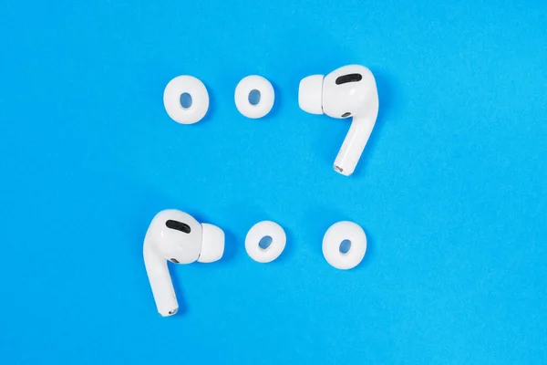 Rostov, Russia - July 06, 2020: wireless headphones Apple AirPods Pro, open case and soft, flexible silicone tapered tips lined up on blue background, top view, copy space. — Stock Photo, Image