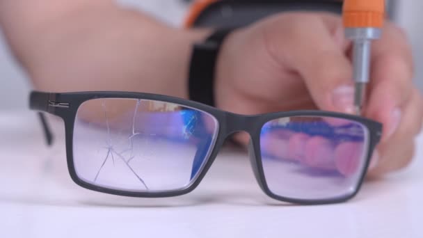 Master sekrup kecil pada kacamata rusak untuk memperbaiki visi dengan obeng profesional khusus di bengkel, perbaikan aksesoris, menutup — Stok Video
