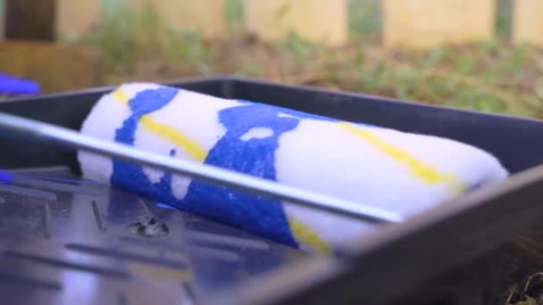 Verfroller rollend in een plastic lade met felblauwe kleurstof. Huisdecoratief concept. — Stockvideo