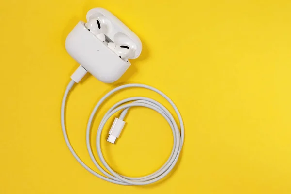 俄罗斯罗斯托夫- 2020年7月6日：无线苹果耳机具有柔软、灵活的硅胶锥形尖端，符合人体耳廓形状的AirPods Pro充电器与电线、顶视图、复制空间相连. — 图库照片