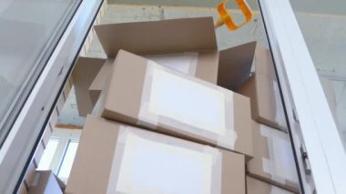 Üzerinde metin etiketleri olan karton kutular balkon kapısından aşağı düşer ve ufalanır, aşağıdan bakıldığında, kapanır. Taşınacak eşyalar, küçük bir dairede depolama sorunu.