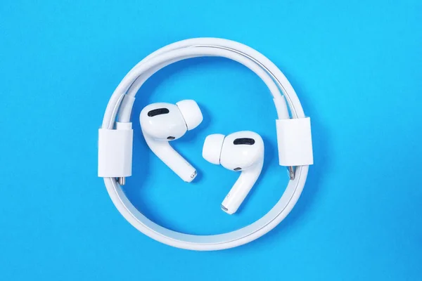 Rostov, Russia - July 06, 2020: Wireless headphones Apple AirPods Pro with soft, flexible silicone tapered tips conforming human ear shape laying in the ring of coiled charging cord, top view, copy — Stock Photo, Image
