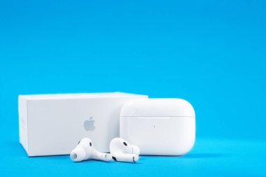 Rostov, Rusya - Temmuz 06, 2020: Yeni açılmış kablosuz kulaklıklar Apple AirPods Pro açık yeniden şarj edilebilir çanta ve mavi zemin üzerine kutu, reklam metni için kopyalama alanı.