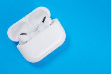 Rostov, Rusya - 06 Temmuz 2020: Apple AirPods Pro kablosuz kulaklıklar aktif gürültü önleyici ses, mavi arkaplan, kopyalama alanı.