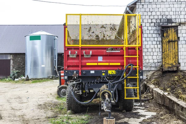 Agricultural machinery on a dairy farm. Trailer-distributor of organic fertilizers from cow manure and straw after working in the field. Front view.